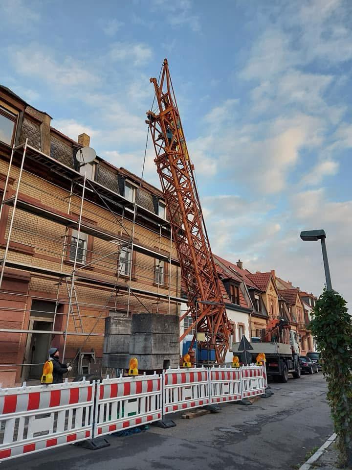 Gerüst und Kran vor einem mehrgeschossigen Bestandsgebäude