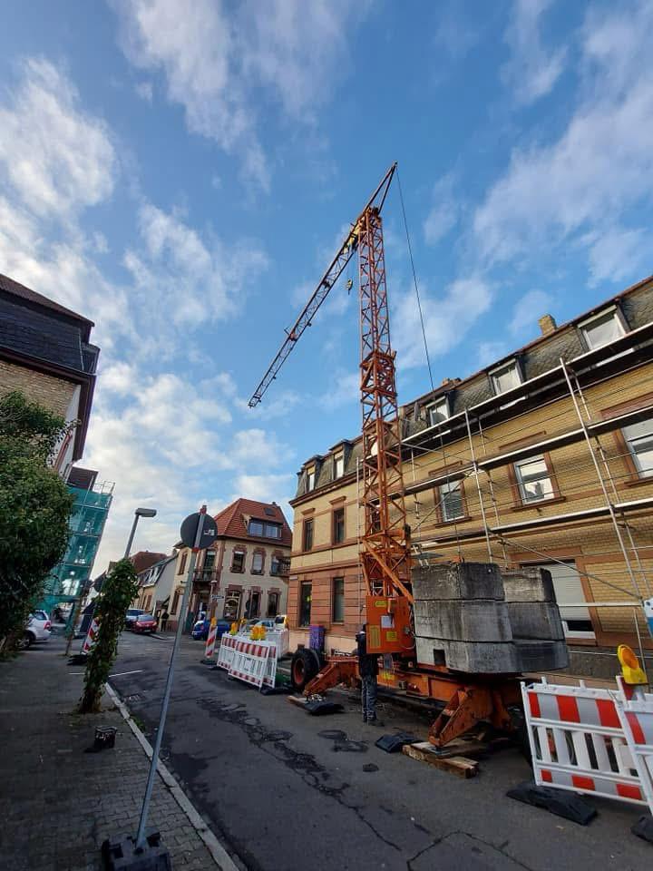 Baustellenkran für den Materialtransport an einem eingerüsteten Gebäude